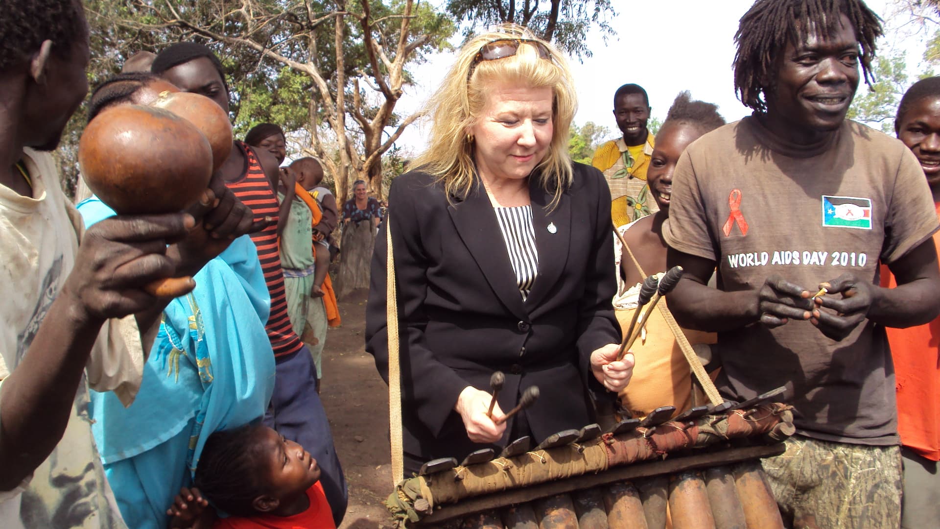 A visiting delegate joining community musicians playing a traditional instrument