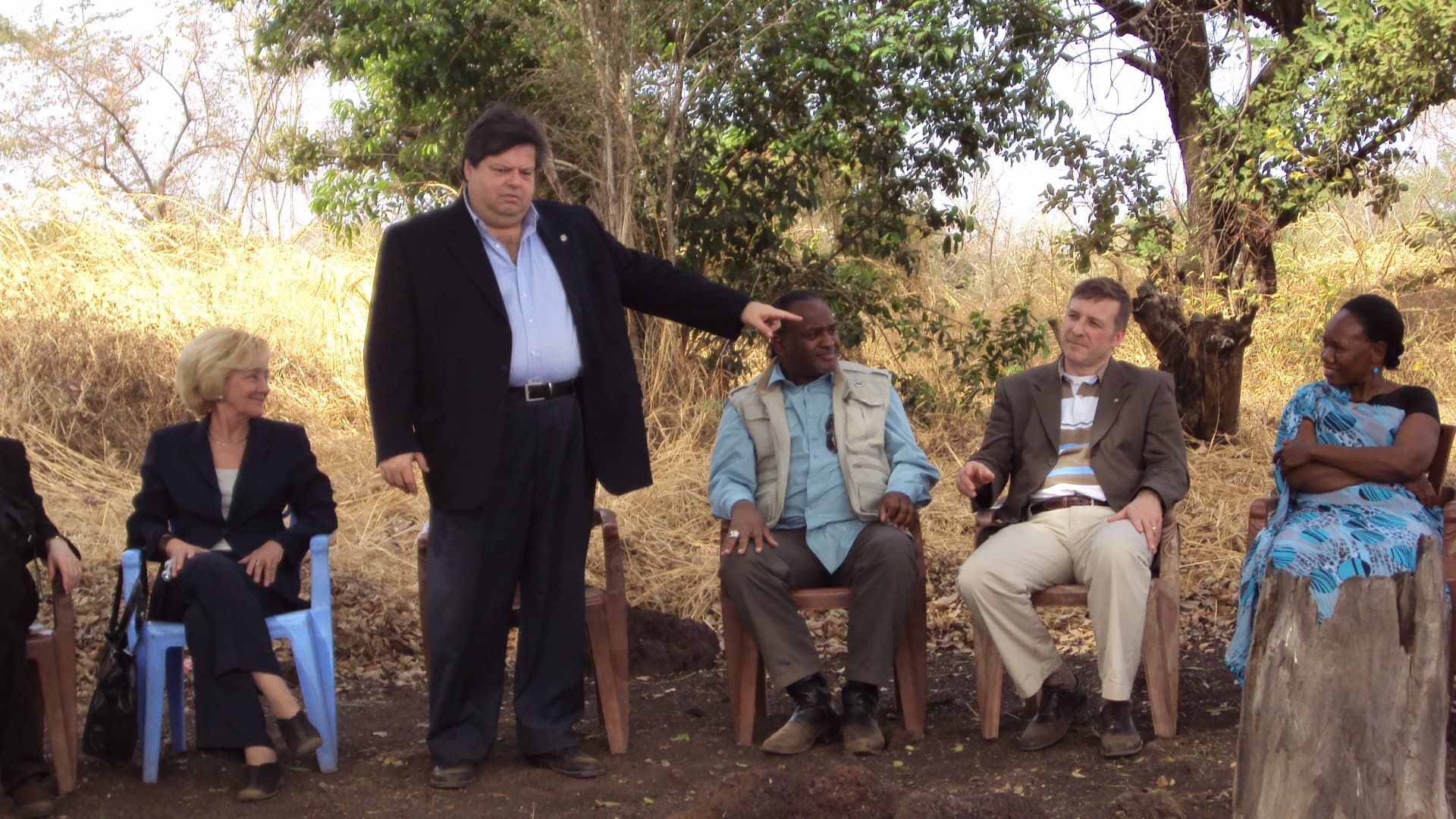 The delegation, WDG representatives and community leaders meeting under a tree to review programme progress