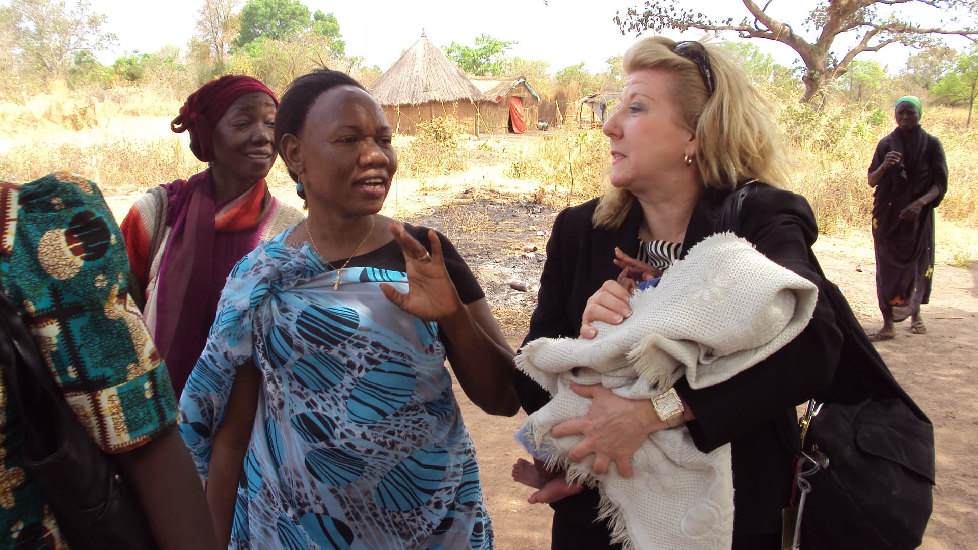 A woman from the community speaking with a member of the delegation about her livelihood